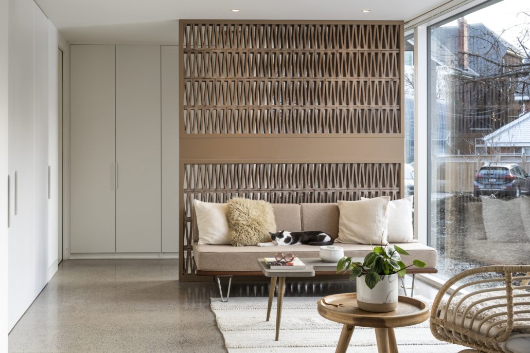 Parkdale, Toronto laneway house living room with wood accent wall and front room divider